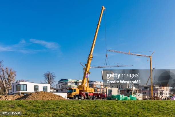 germany, baden-wurttemberg, ludwigsburg, mobile crane at construction site in modern suburb - mobile crane stock pictures, royalty-free photos & images