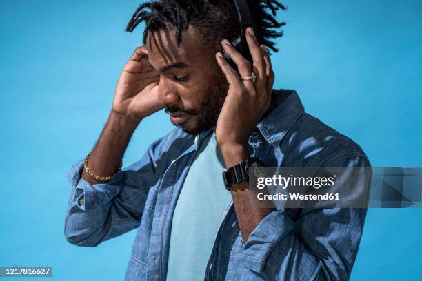 portrait of stylish young man listening to music with headphones - dj portrait stock pictures, royalty-free photos & images