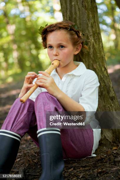portrait of girl playing recorder in forest - flauto foto e immagini stock