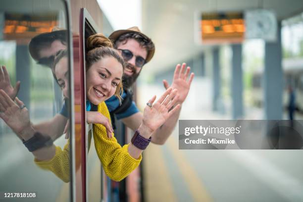 couple waving from the train window - waving goodbye stock pictures, royalty-free photos & images