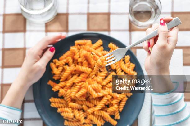 woman eating pasta at dining table at home - dining overlooking water stock-fotos und bilder
