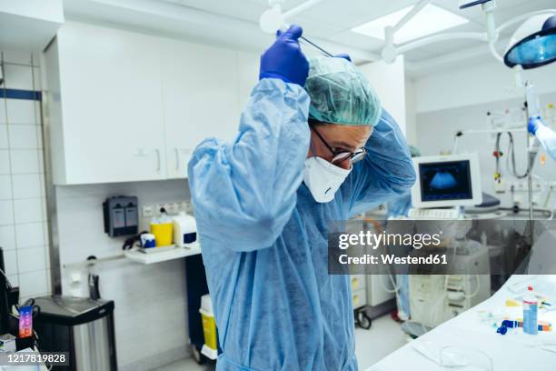 doctor putting on ffp2 mask in emergency room of a hospital - acute care stock pictures, royalty-free photos & images