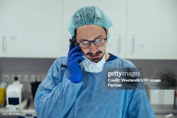 portrait of a doctor on the phone in a hospital - notfallmedizin stock-fotos und bilder