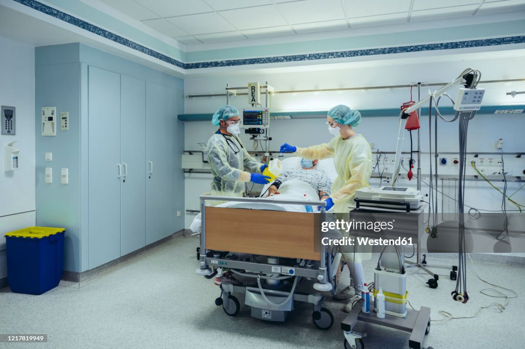 Doctors caring for patient in emergency care unit of a hospital taking blood sample