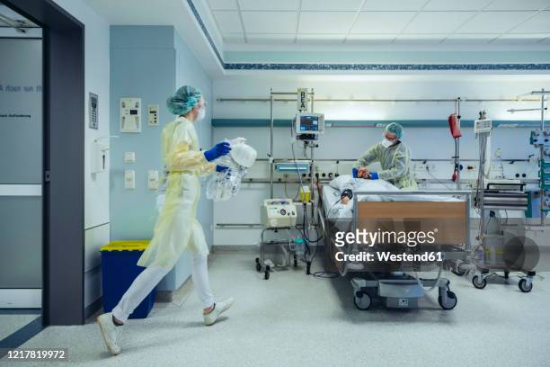 doctors in a hurry caring for patient in emergency care unit of a hospital - hospital ward stock-fotos und bilder