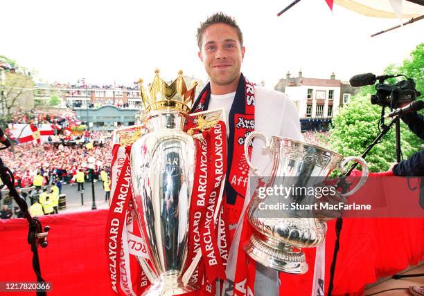 Matthew Upson of Arsenal with the Premier League Trophy and the FA Cup Trophy during the Arsenal Trophy Parade on May 12, 2002 in London, England.