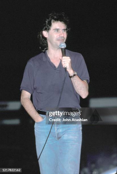 Comedian Dennis Miller is shown performing on stage during a "live" concert appearance on July 10, 1989.