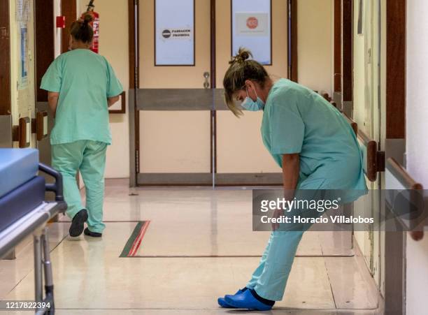 Nurse technician wearing protective mask shows her tiredness at the end of her shift in the intermediate ward for COVID-19 Coronavirus patients in...