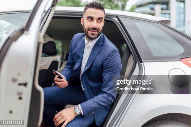 handsome businessman riding in the car - car leaving stock pictures, royalty-free photos & images