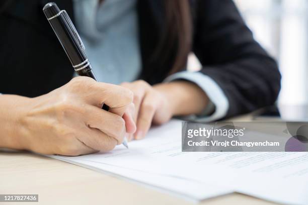 close-up business woman hand signing the contract to conclude a deal - deal signing stockfoto's en -beelden