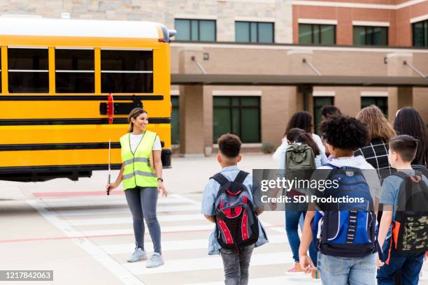 wenn kinder zum bus kreuzen, stoppt die querwache den verkehr - cross road children stock-fotos und bilder