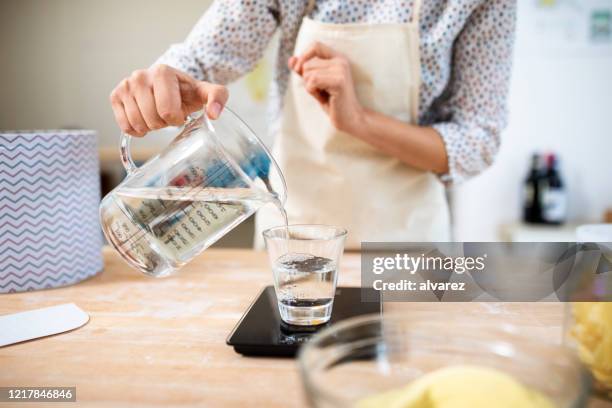 close-up van een vrouwelijke chef-kok die in keuken kookt - jug stockfoto's en -beelden