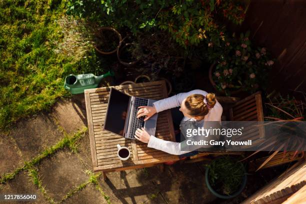 woman working from home in her garden - telecommuting stock pictures, royalty-free photos & images