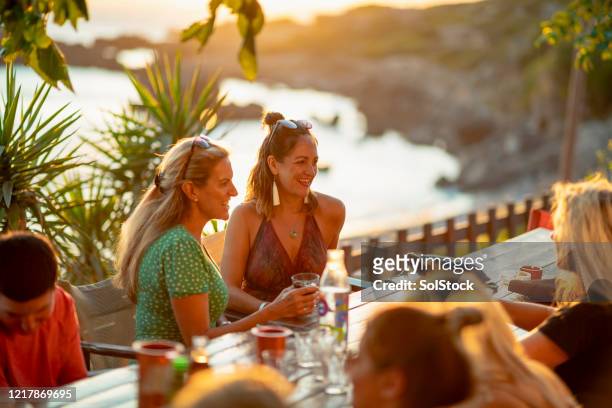 dining at the beach taverna - evening meal restaurant stock pictures, royalty-free photos & images