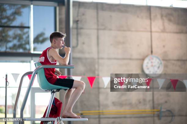 lifeguard on tower blowing whistle - lifeguard stock pictures, royalty-free photos & images