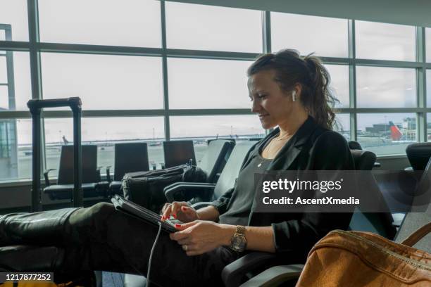 de vrouw wacht in luchthaven en controleert e-mail bij dageraad - woman blond looking left window stockfoto's en -beelden