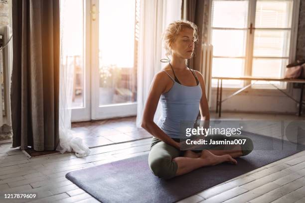 junge sportliche frau, die yoga praktiziert - yoga stock-fotos und bilder