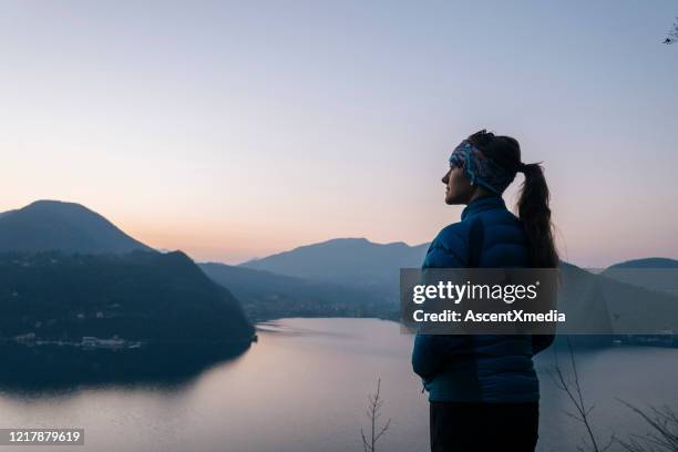 female hiker walks above lake and european alps - self discovery stock pictures, royalty-free photos & images