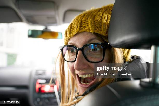 woman turning round in the car and making a silly face - driving humor stock pictures, royalty-free photos & images