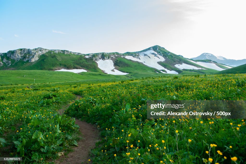 Landscape with meadow and snow-covered hills, Kamennomostsky, Adygea, Russia