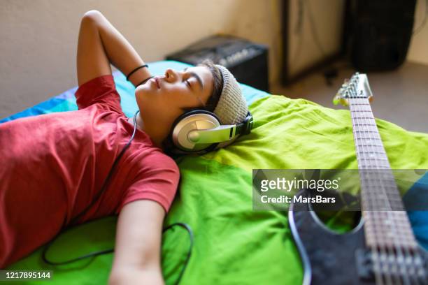 latinx pre-teen junge hören musik ruhig in seinem schlafzimmer - young boy enjoying music stock-fotos und bilder