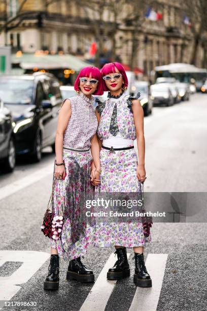 Fashion twins Ami Suzuki and Aya Suzuki "Amiaya" are seen, and wear a floral print dress, sunglasses, a pink sequined shiny bag, black leather boots,...