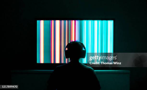 person sitting in front of a tv screen with headphones - saturated color stock pictures, royalty-free photos & images