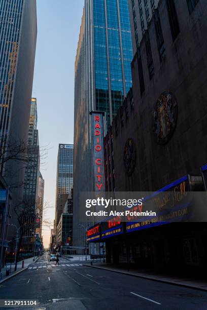 the view on radio city music hall along w50th street deserted because of the covid-19 outbreak. - music hall center stock pictures, royalty-free photos & images