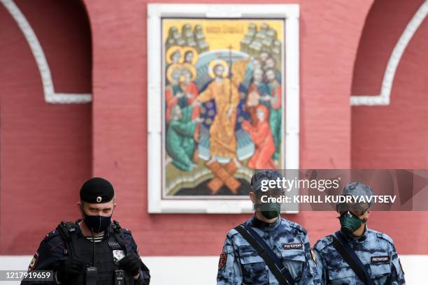 Police officer and National Guard servicemen wearing protective face masks patrol during the annual book fair on the Red Square in downtown Moscow on...