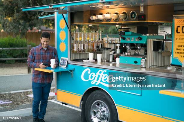 young man drinking coffee by a food truck - food truck street stock pictures, royalty-free photos & images