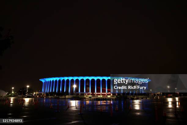 The Forum is illuminated in blue lights during the coronavirus pandemic on April 09, 2020 in Inglewood, United States. Landmarks and buildings across...