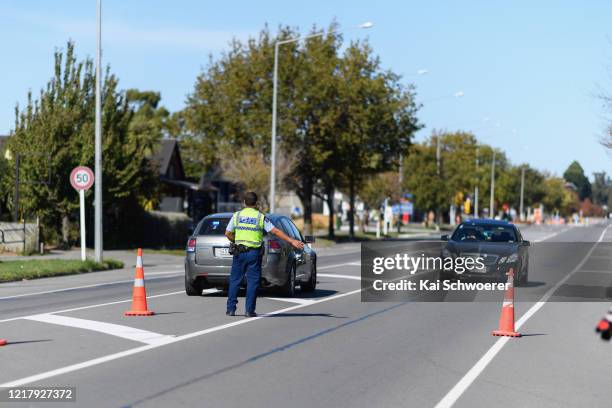 Police officer stops cars travelling north towards Hanmer Springs at a checkpoint on April 10, 2020 in Amberley, New Zealand. With New Zealand in...