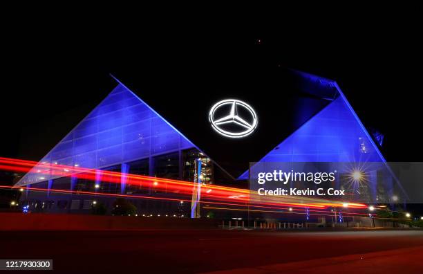 View of Mercedes-Benz Stadium as it is lit up with blue lights on April 09, 2020 in Atlanta, Georgia. Landmarks and buildings across the nation are...