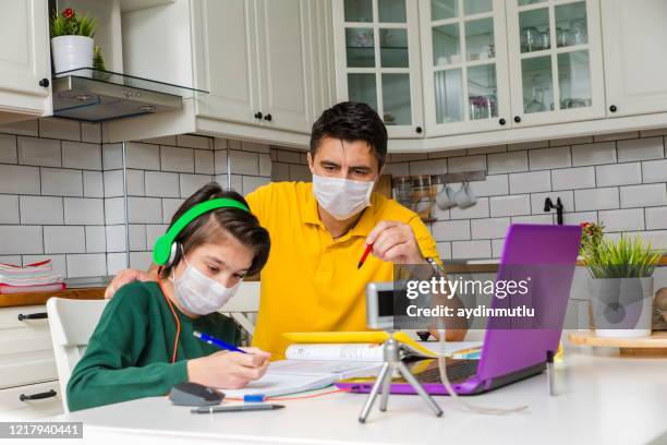 father and son in video chat with teacher wearing masks - coronavirus social distancing stock pictures, royalty-free photos & images