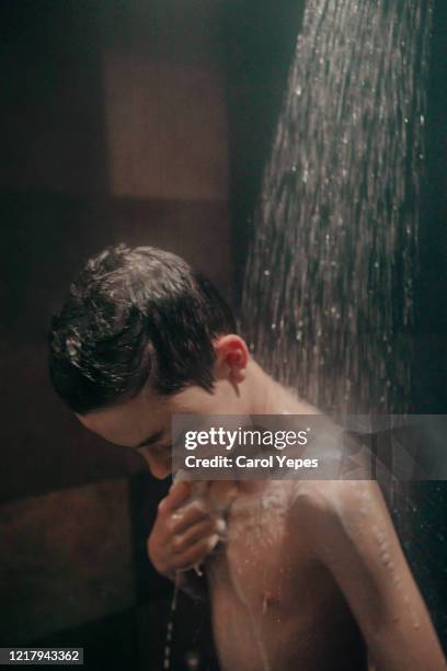 teen boy enjoying shower - boy taking a shower stock-fotos und bilder