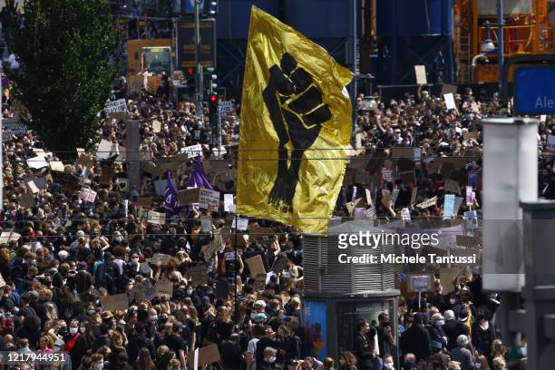 Alexanderplatz seen fully crowded with people holding banners and placards as they stand in silence for eight minutes and 46 seconds in tribute to...