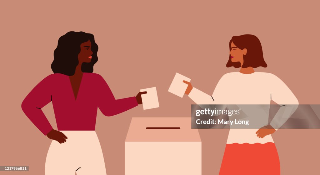Two Strong girls are putting paper ballot in box.