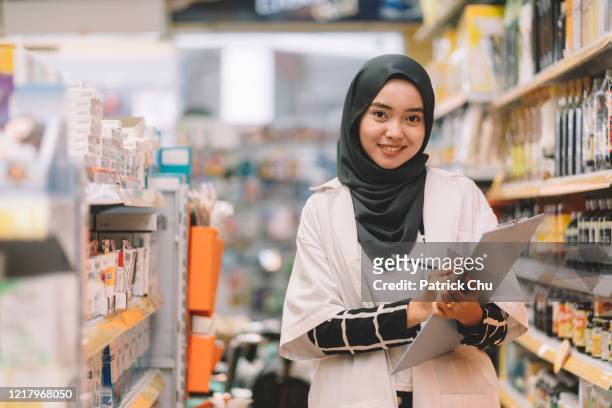 giovane donna farmacista musulmana asiatica che lavora al negozio di farmacia - islam foto e immagini stock