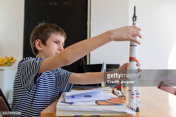 boy playing on a break from studying online - model rocket stock pictures, royalty-free photos & images