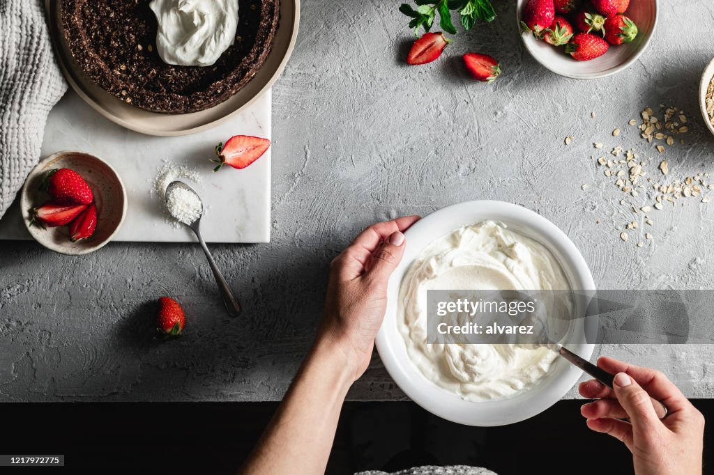Chef femenina mezclando yogur en un tazón