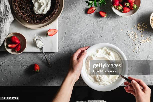 chef fêmea misturando iogurte em uma tigela - decorating a cake - fotografias e filmes do acervo