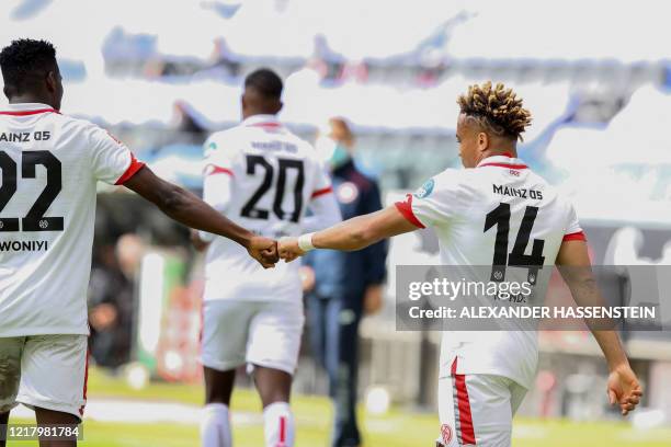 Mainz' Cameroonian midfielder Kunde Malong fist bumps Frankfurt's US defender Timothy Chandler after scoring during the German first division...