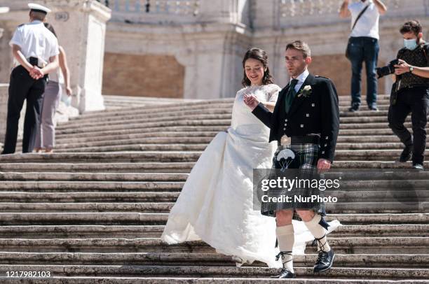 The bridegroom wears a kilt, the traditional Scottish dress, as a marrying couple takes photos on the Spanish Steps, aftger the authority ease...