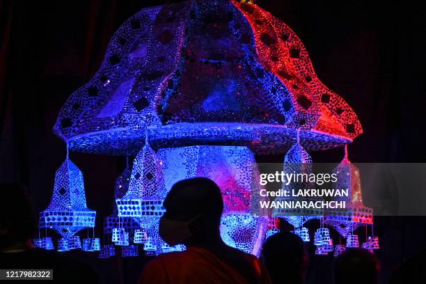 Visitors look at lanterns displayed near Sri Lanka's military headquarters in the capital Colombo on June 6 a day after the Poson Poya religious...