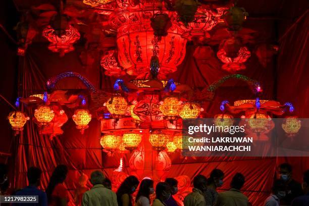 Visitors look at lanterns displayed near Sri Lanka's military headquarters in the capital Colombo on June 6 a day after the Poson Poya religious...