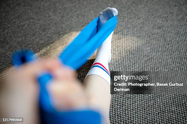 part of a runner woman stretching her leg and foot with a resistance band - calf imagens e fotografias de stock