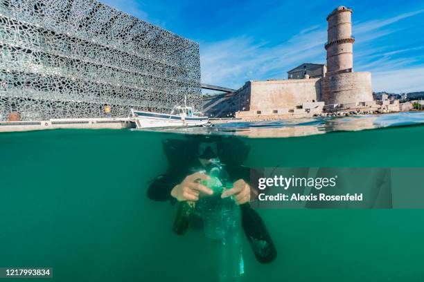 In front of MUCEM, a scientific diver from Septentrion Environnement, picks up plastic and glass bottles during a cleaning operation of the historic...