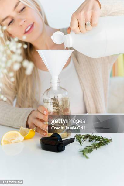 woman making a homemade natural cleaner - azijn stockfoto's en -beelden