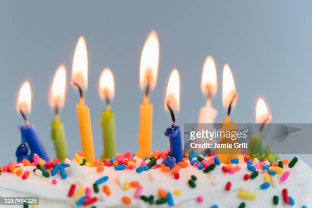 lit birthday candles on cake - birthday cake stock pictures, royalty-free photos & images