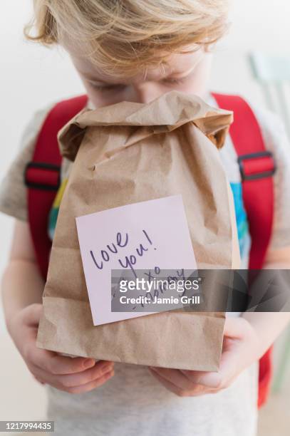 boy (4-5) peeking into lunch bag with note from mom - packed lunch - fotografias e filmes do acervo